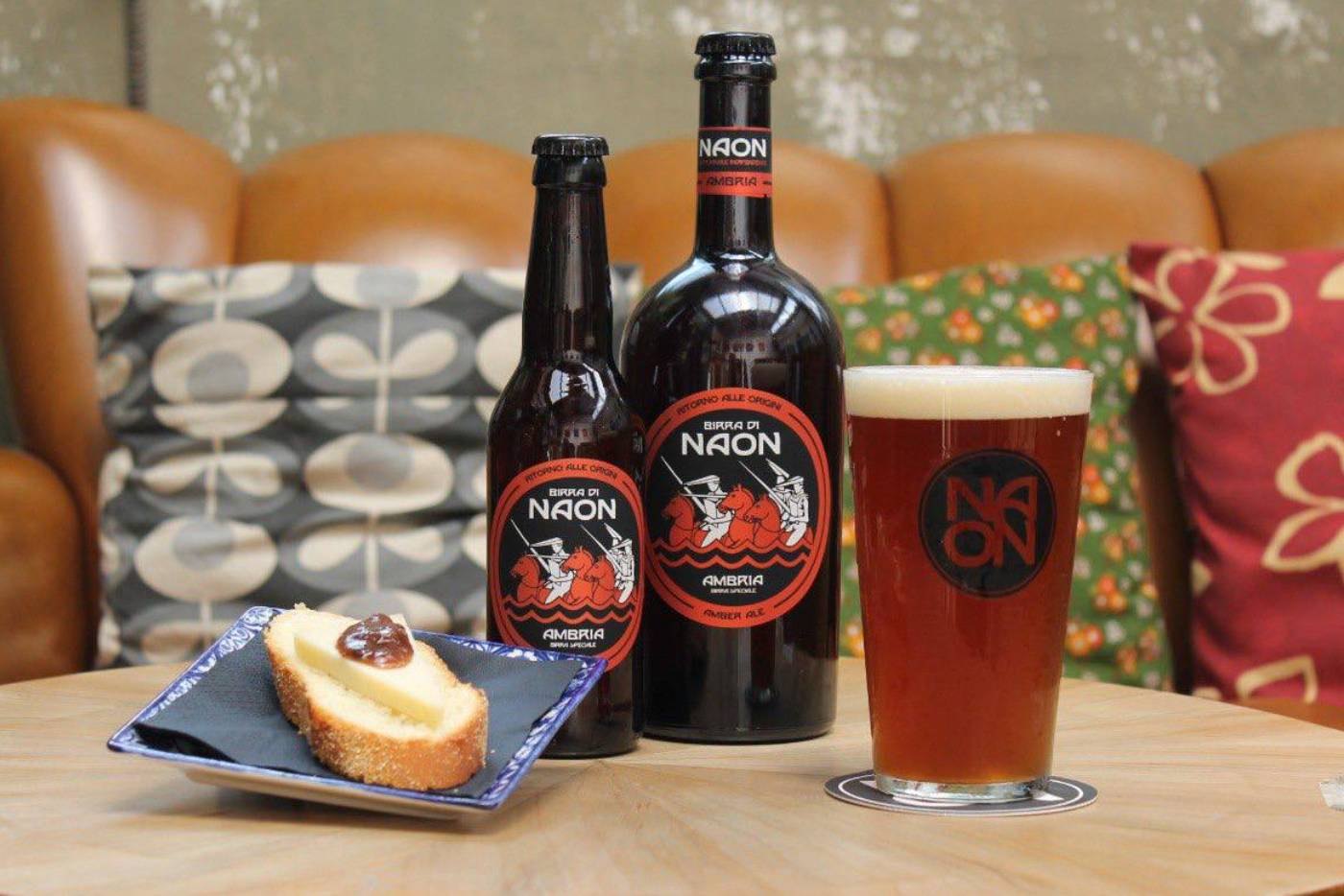 Bottiglie di Ambria con una pinta e un dolce sul tavolo del pub