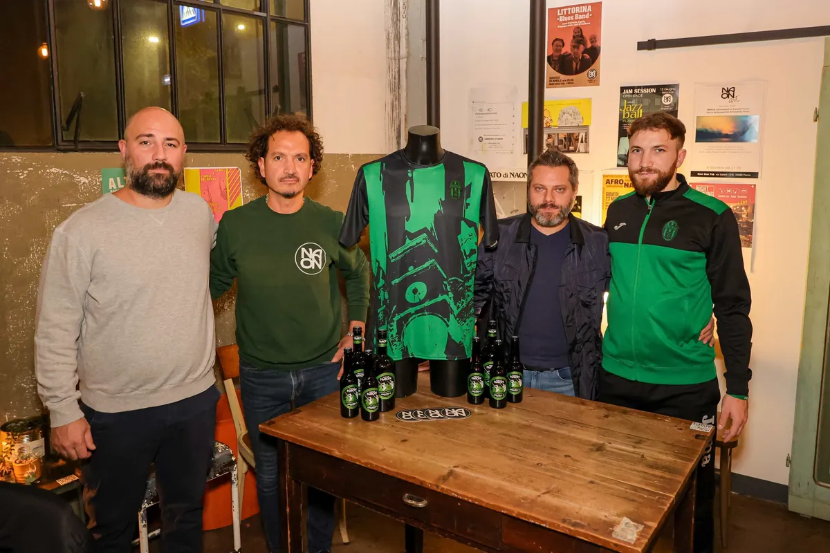Quattro persone accanto alla maglia del Pordenone Calcio a 5 e alle bottiglie di Coglians 5
