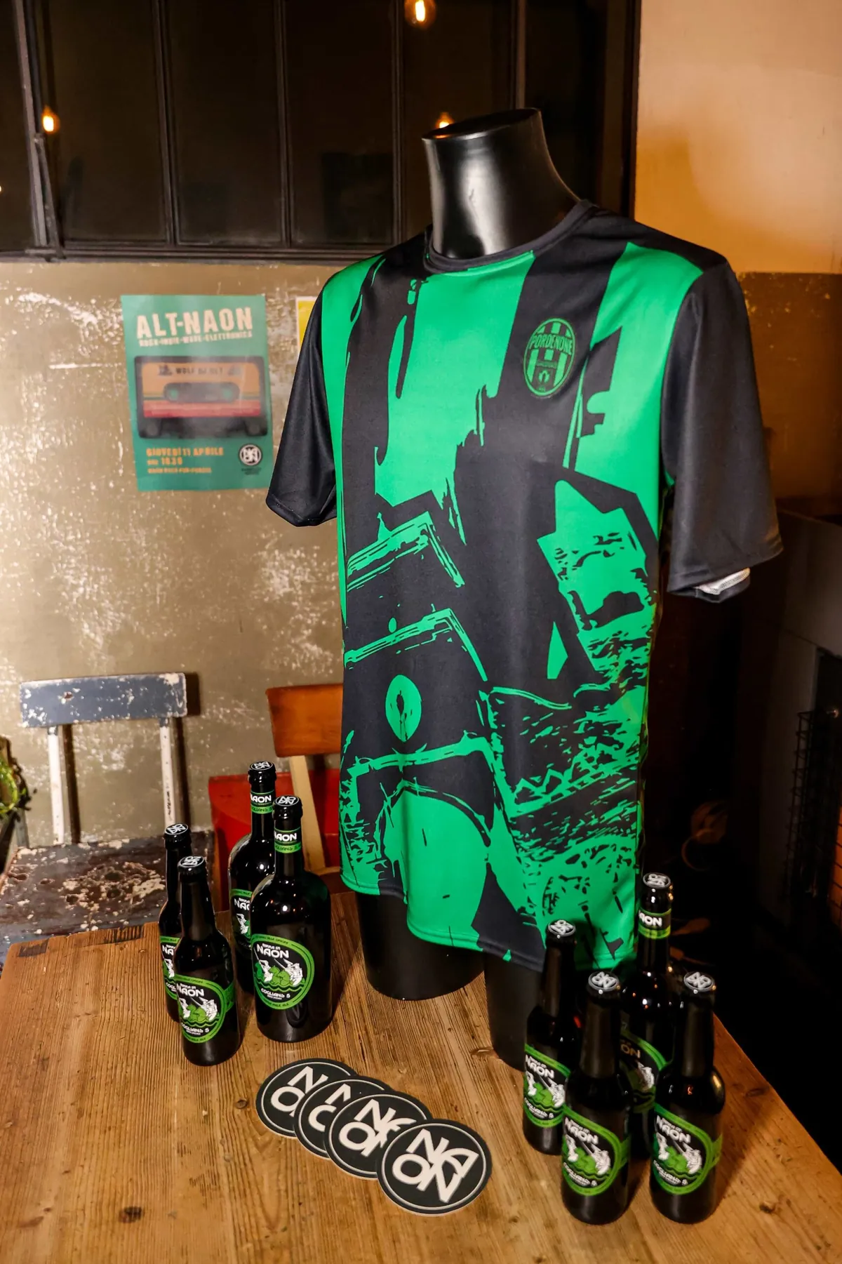 La maglia neroverde del Pordenone Calcio a 5 esposta al pub con le bottiglie di Coglians 5